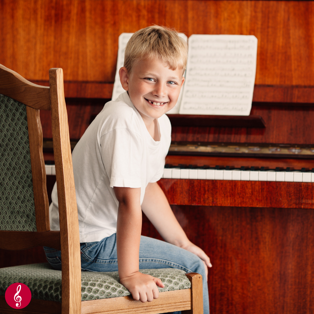 Happy boy sitting at piano